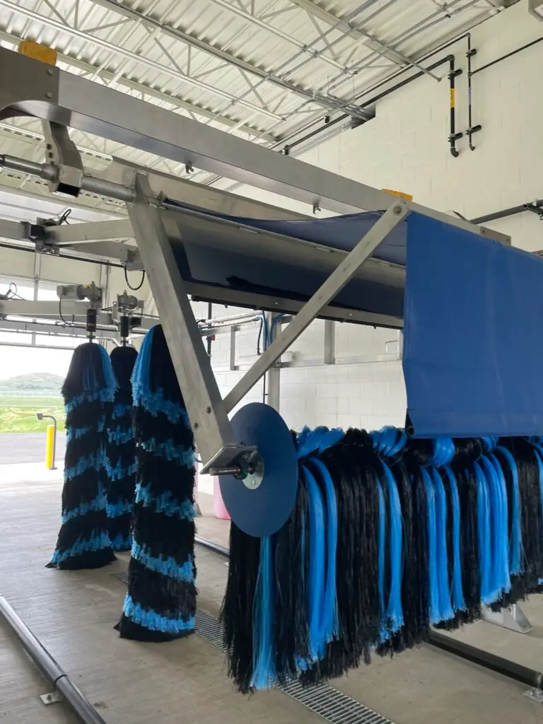 Post construction interior of the Yellowstone Regional Airport Car Wash Quick Turnaround Facility car wash bay completed by Groathouse Construction featuring sloped concrete floors and car wash machinery